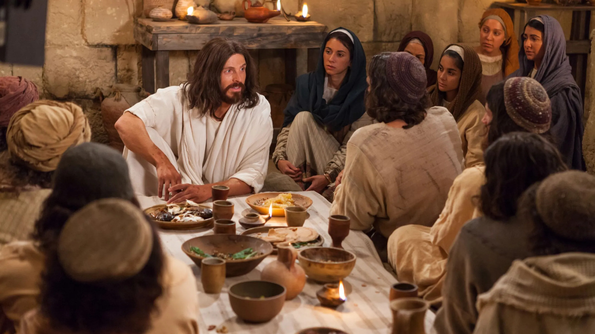 Jesus Christ sits at a meal with his apostles and followers after his resurrection in this image from the Bible Videos published by The Church of Jesus Christ of Latter-day Saints.
