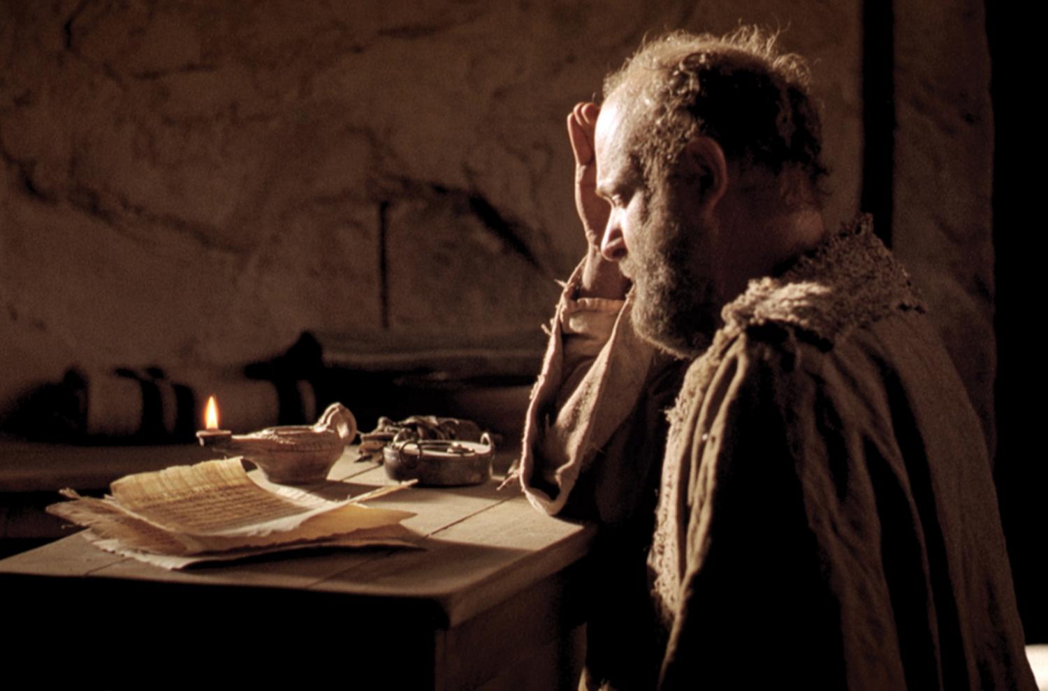 Paul sits in a jail cell, writing an epistle. Image from Bible Videos of The Church of Jesus Christ of Latter-day Saints.