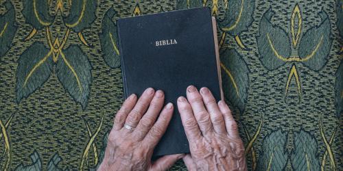 Two aged hands hold a Bible. Image from Pexels via Pixabay.